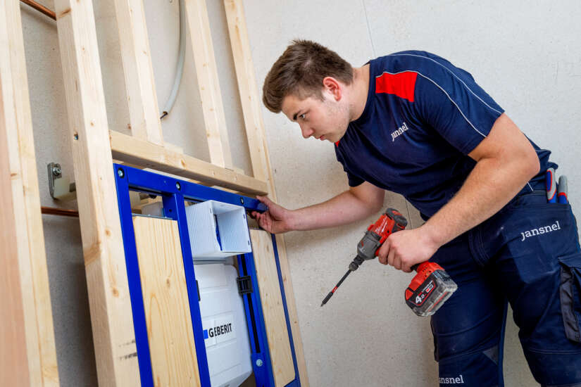 Loodgieter Modulaire Bouw medewerker in werkkleding van Jan Snel met boor in zijn hand