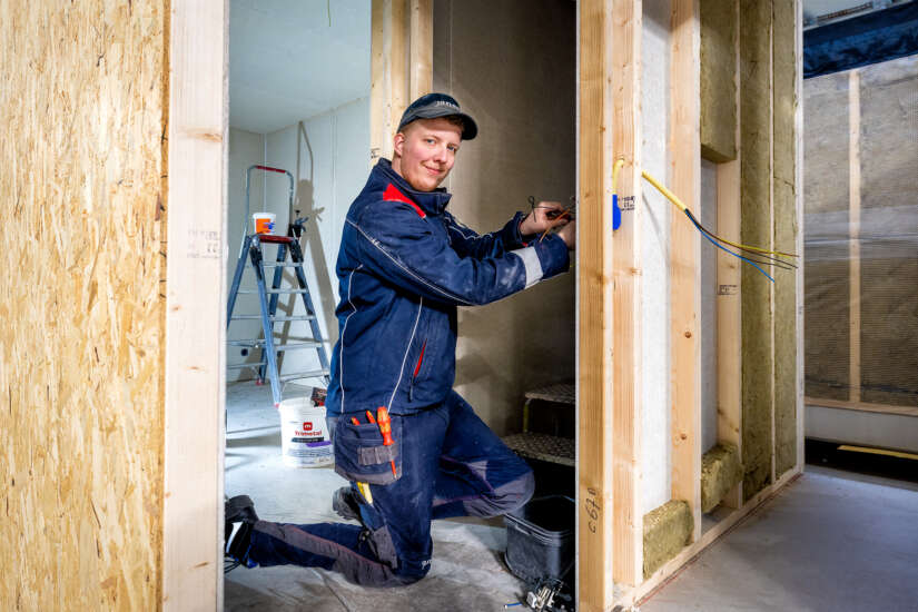 Medewerker aan het werk in productiehal in werkkleding van Jan Snel