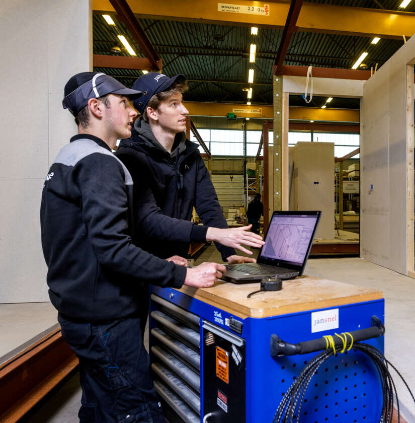 Twee medewerkers die hun werkzaamheden controleren aan de hand van een gedigitaliseerde tekening op een laptop.
